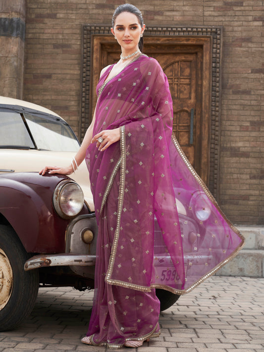 Pink colored shimmer net saree with sequinned butti and embroidered border