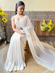 ساري نسائي من قماش الجورجيت بلون أبيض كريمي مزين بتطريزات، مع قطعة بلوزة.