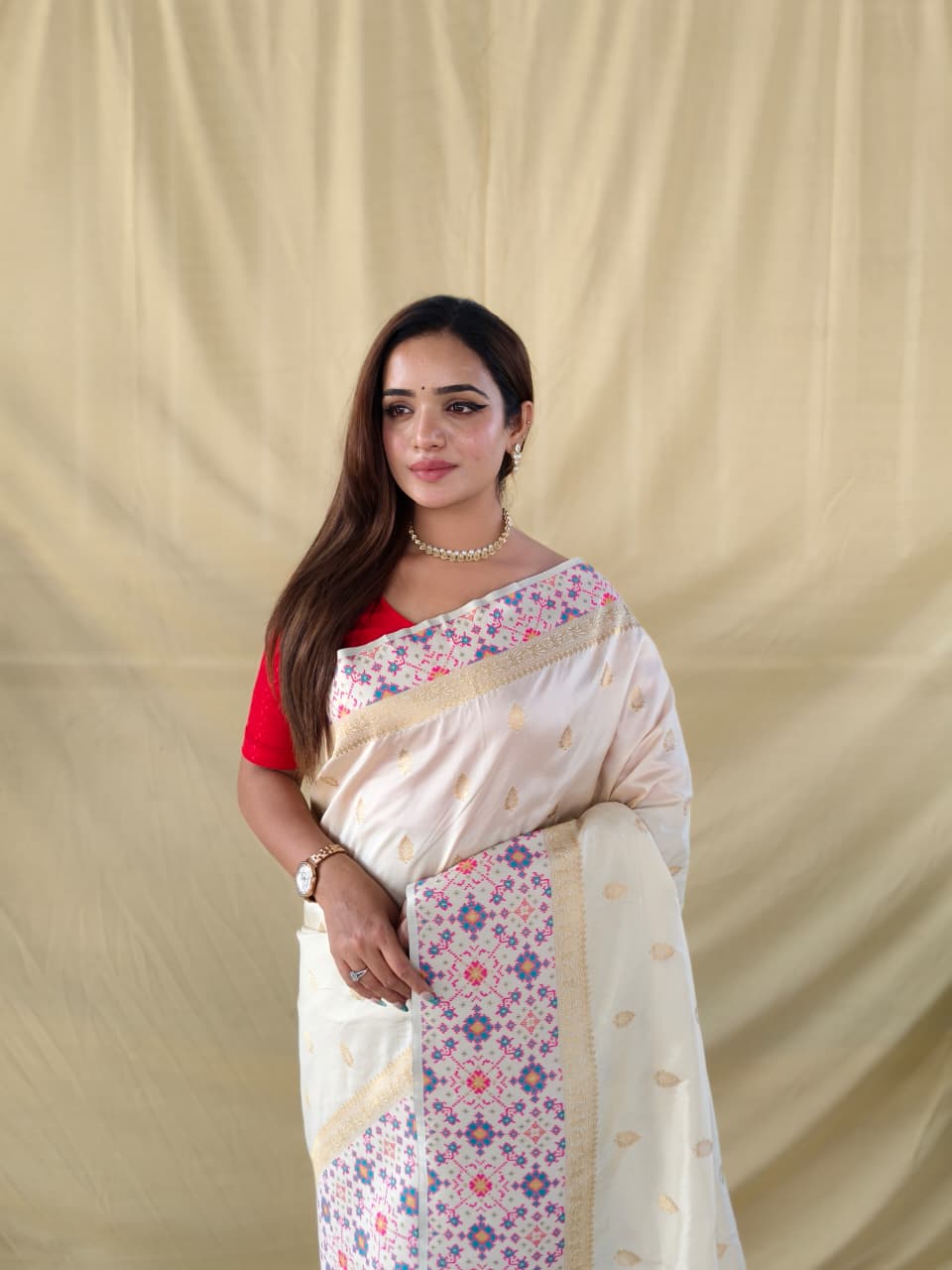 soft silk saree in pure white. Beautifully enhanced with Patola-inspired meenakari weaving on both borders, the saree features a richly woven pallu that adds a royal touch
